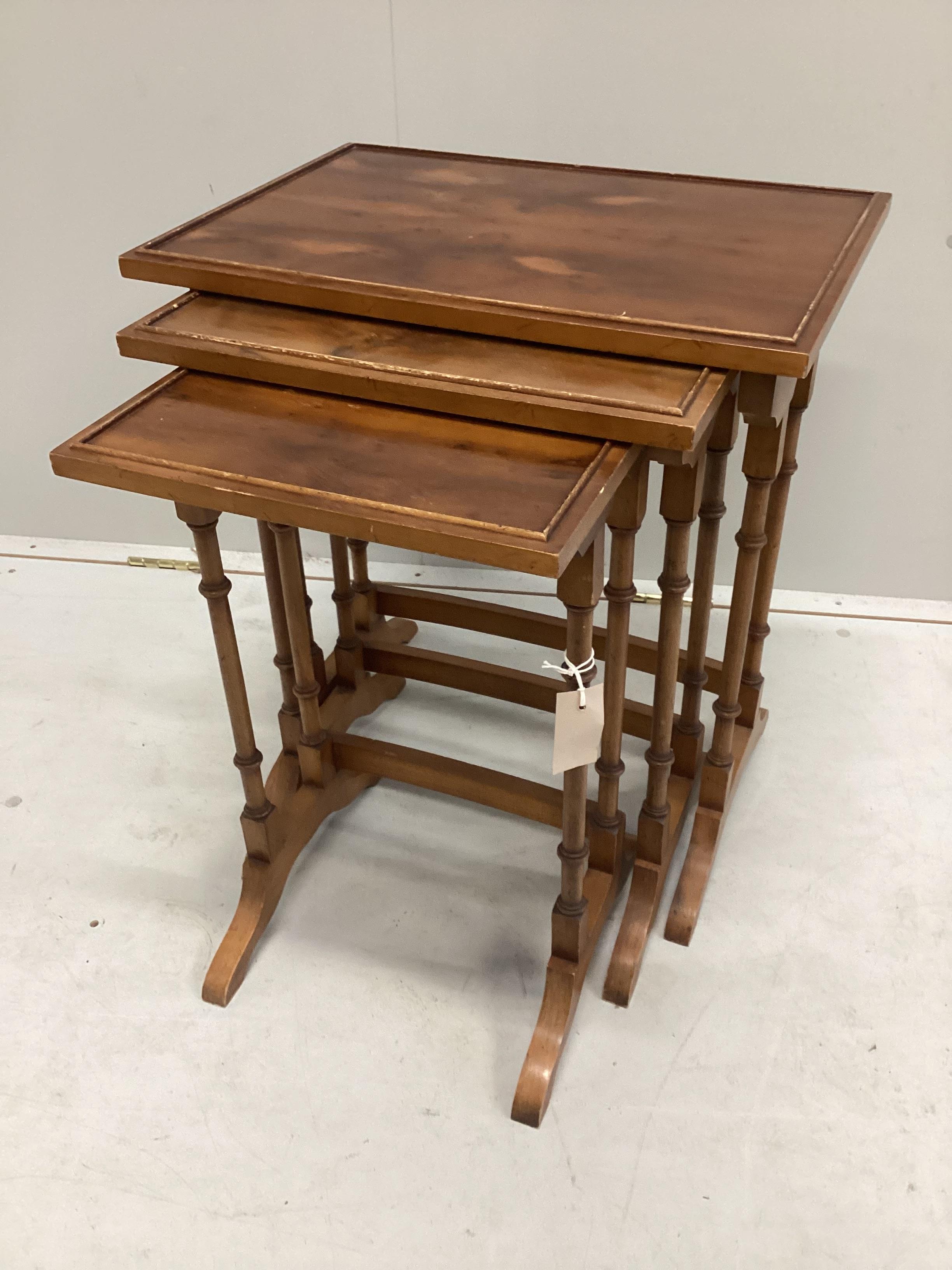 A nest of three reproduction yew tea tables, width 51cm, depth 35cm, height 57cm